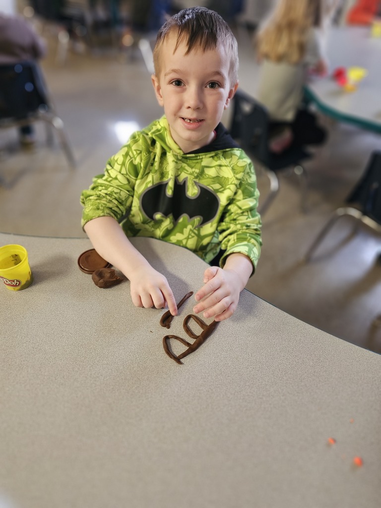 Happy student making letters with  playdoh