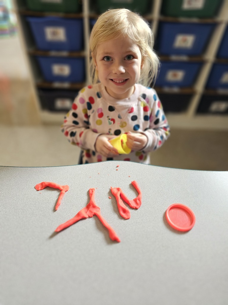 Happy student making letters with  playdoh