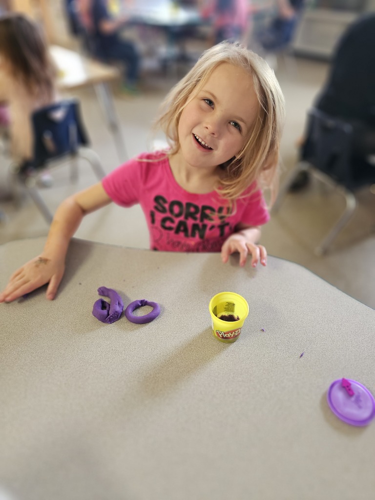 Happy student making letters with  playdoh