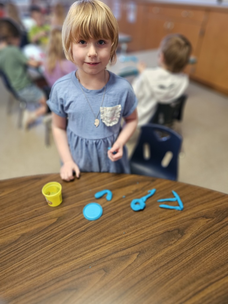 Happy student making letters with  playdoh