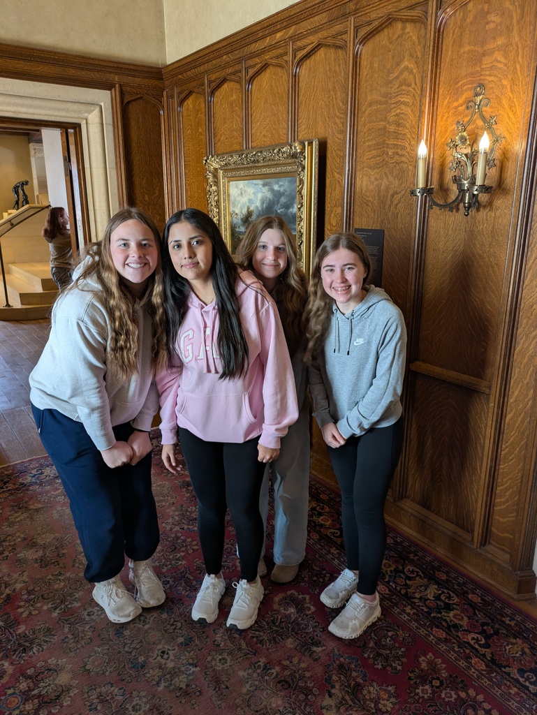 Four students stopping to take a picture at  Paine Arts and Gardens Center