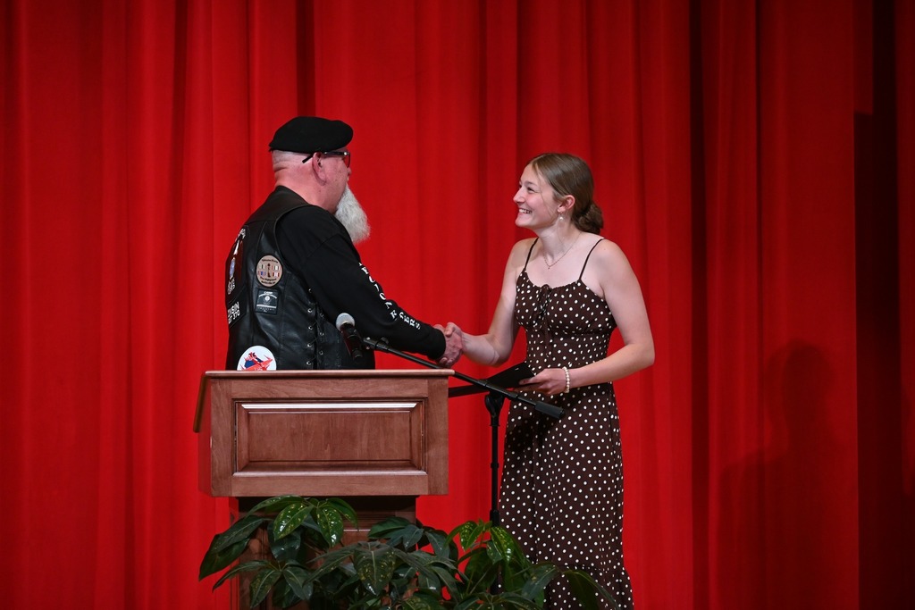 A happy student accepting her award