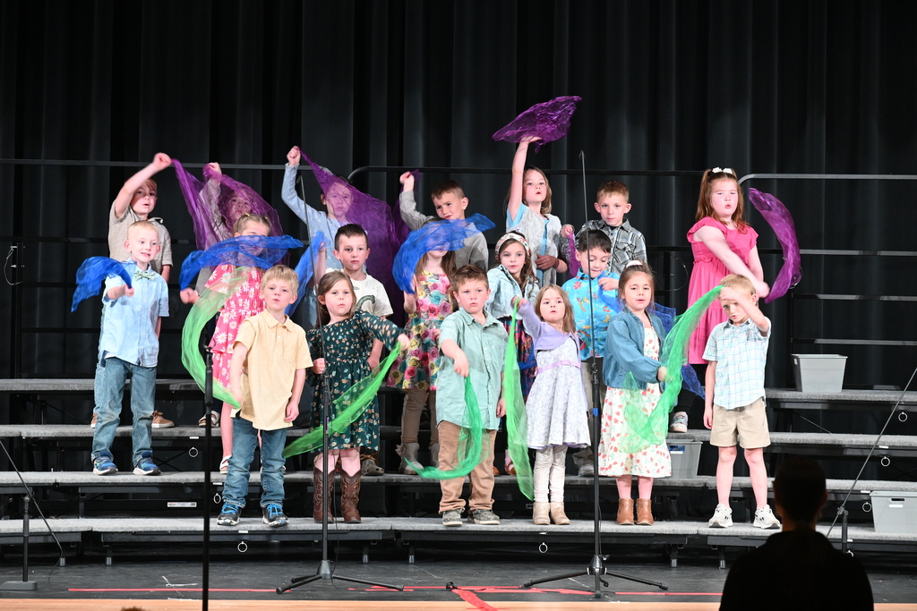 Students waving colorful scarves during their performance. 
