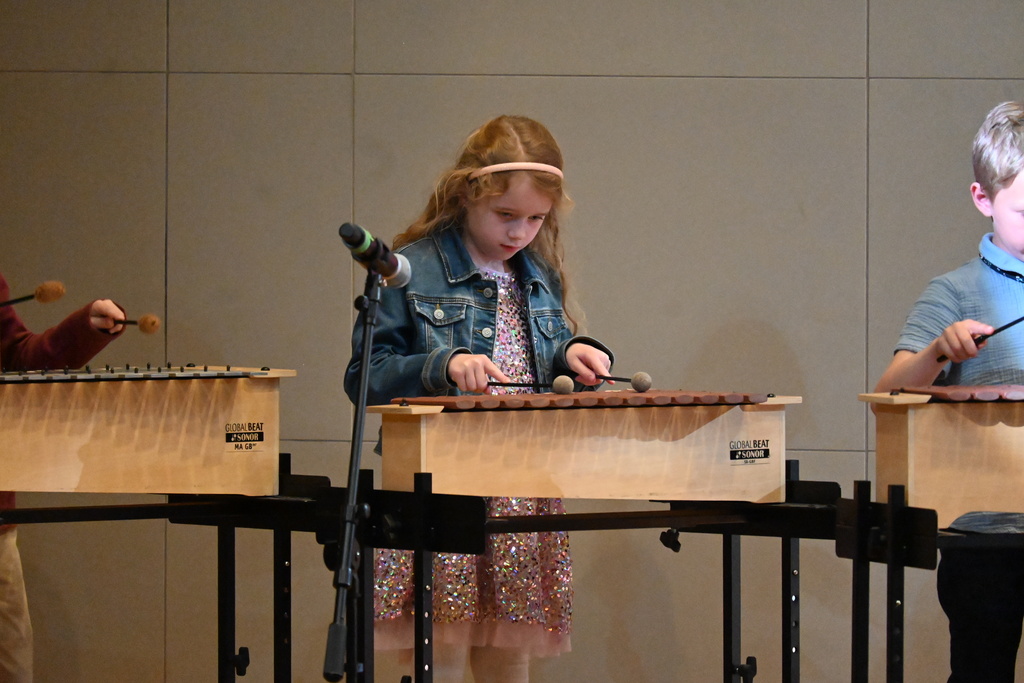 A student intently playing the xylophone. 