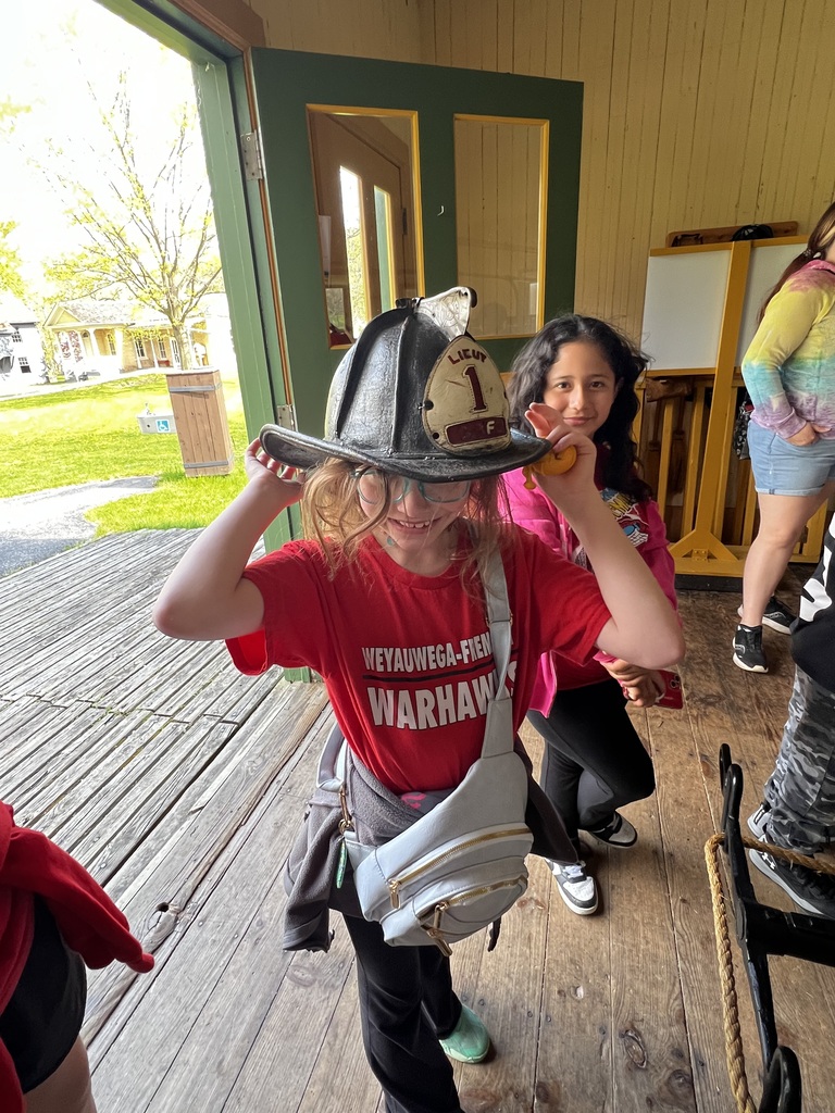 Student trying on a fireman's hat at Heritage Hill