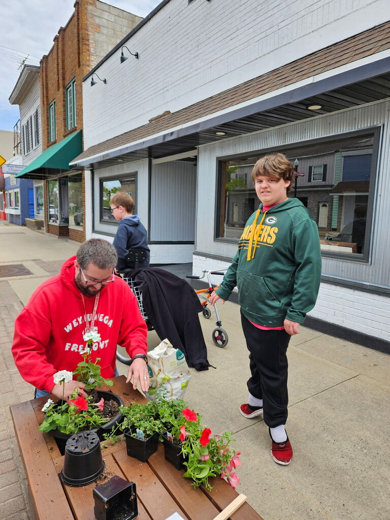 WF members placing flowers in the planter