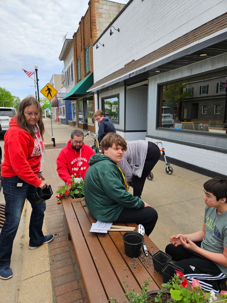 Our WF students getting their hands dirty while putting flowers in the planters
