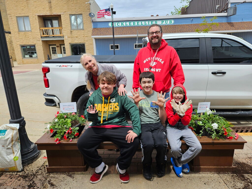 Our students showing off their hard work on the planter in town