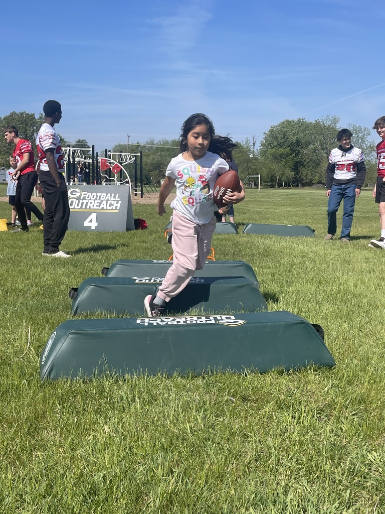 Student holding a football while completing the obstacle course.