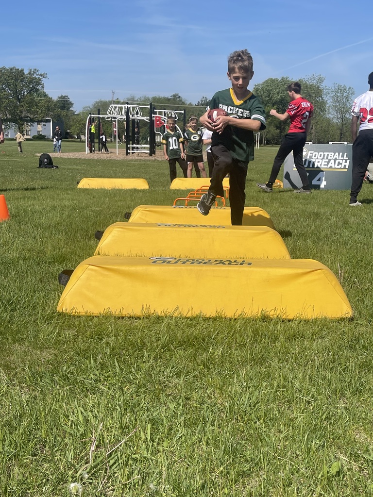 A Packer fan holding tightly on to the football while completing an obstacle course