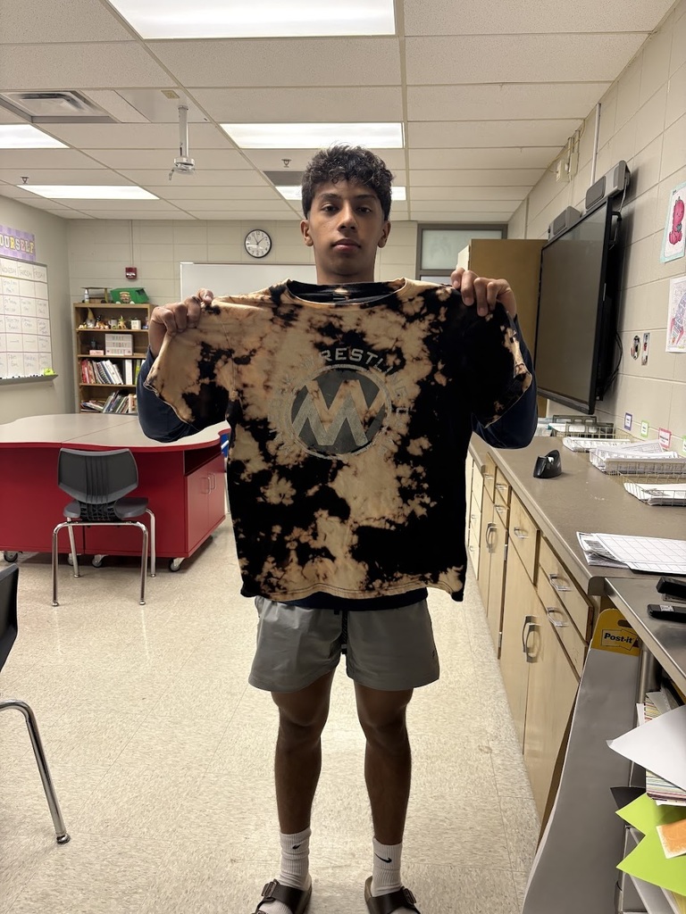 Student proudly holding up their finished tie-dye shirt.