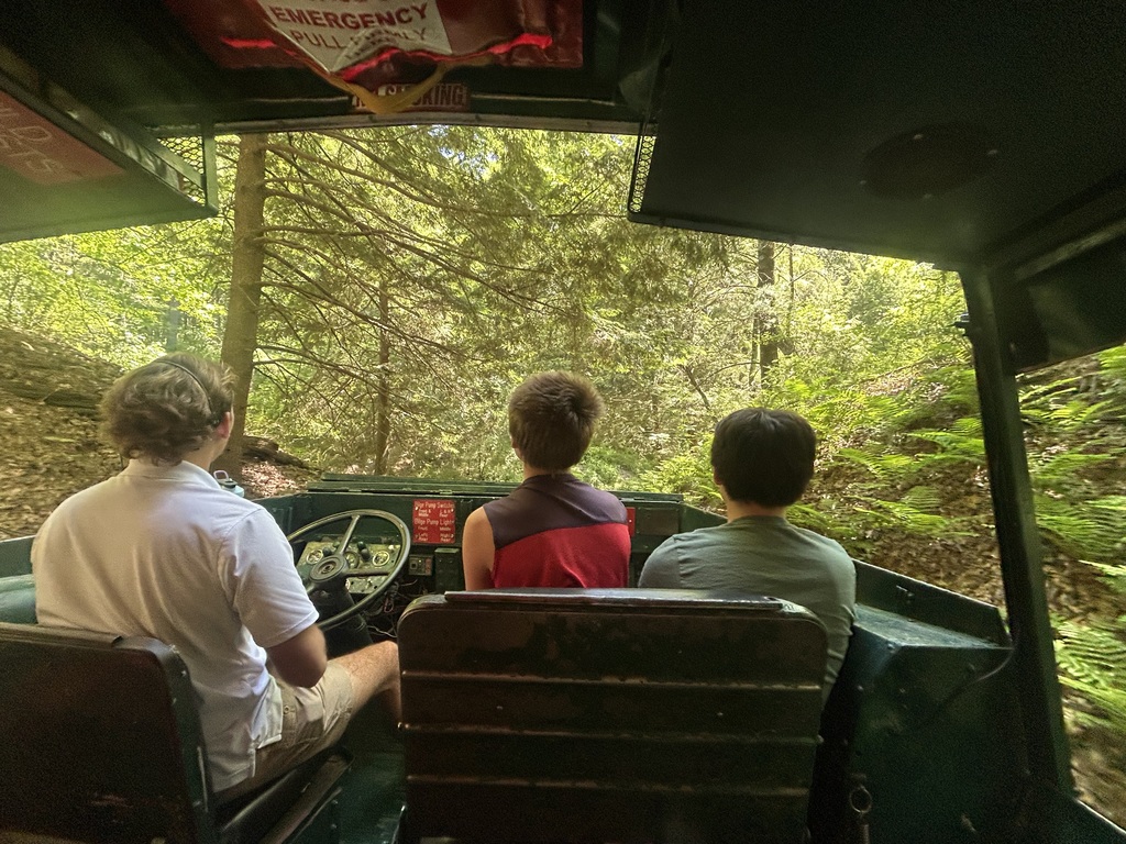 Two students and the driver in front of the boat as they explore Wisconsin Dells