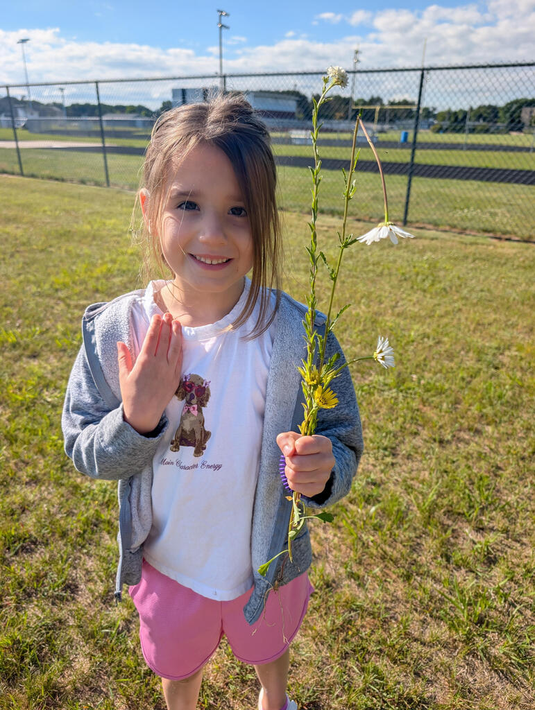 Student happily showing off the flowers she picked while on the nature walk. 
