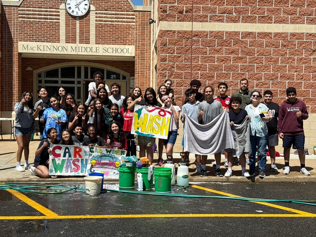 Students standing outside with car wash signs