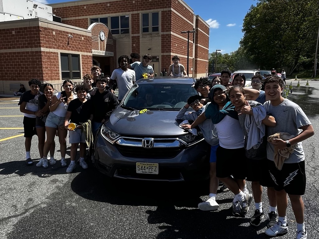 Students standing infront of car they cleaned