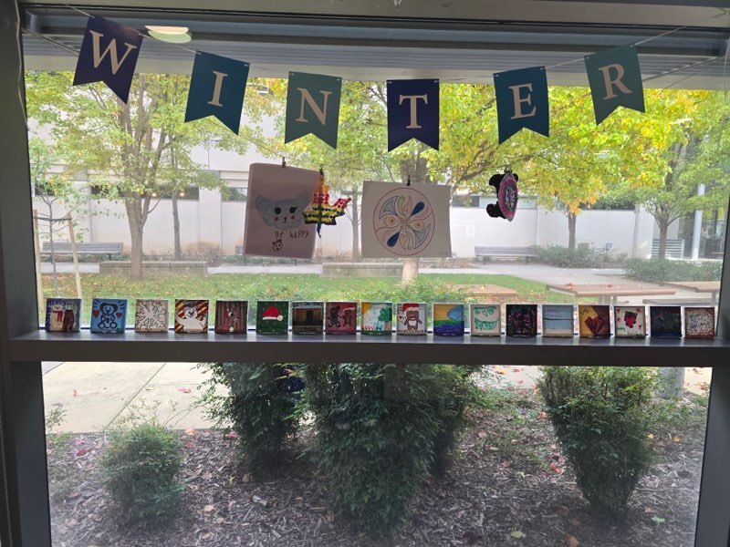 Art displayed on a windowsill under the sign Winter