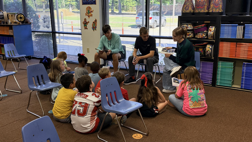 pictures from The WHHS Chick-fil-A Leader Academy service project, donating books to students and reading books