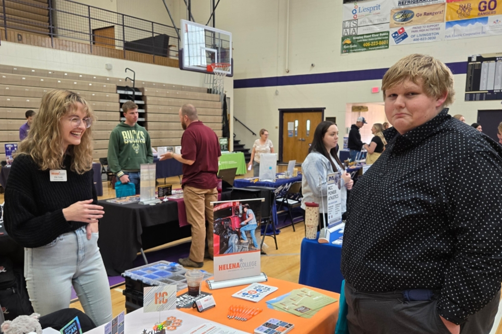 A student visits with Helena College at the College and Career Fair.