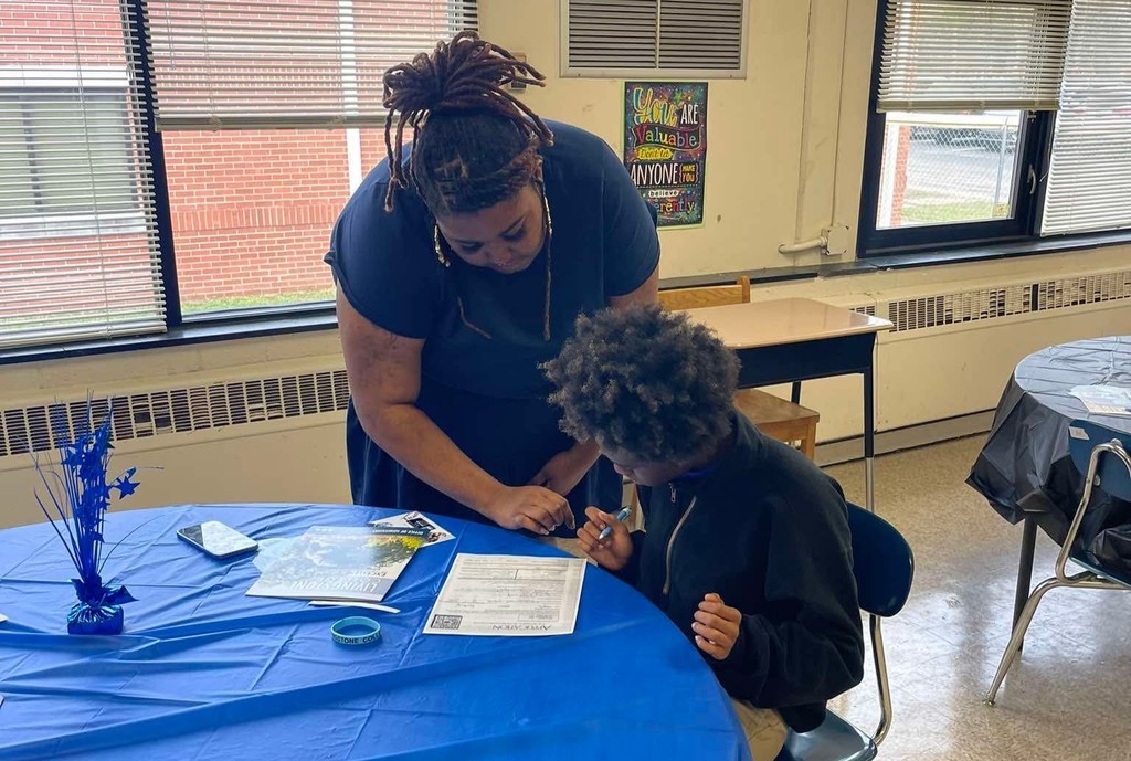 NWA Graduation Coach, Ms. Kwabena Meares assisting a student. 
