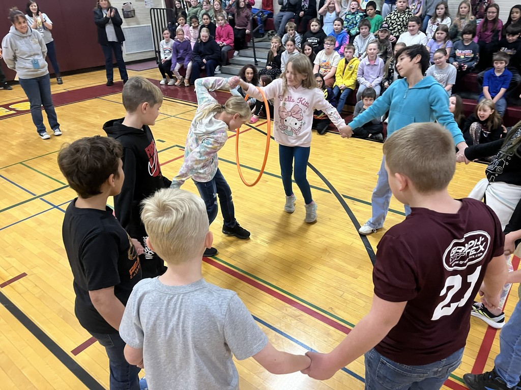 group of students in a circle with a hula hoop