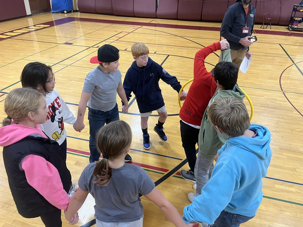group of students in a circle with a hula hoop