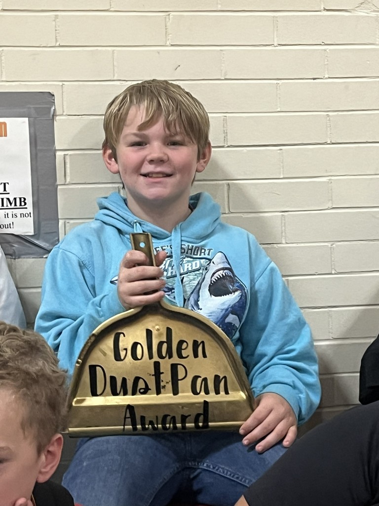 student with golden dust pan award