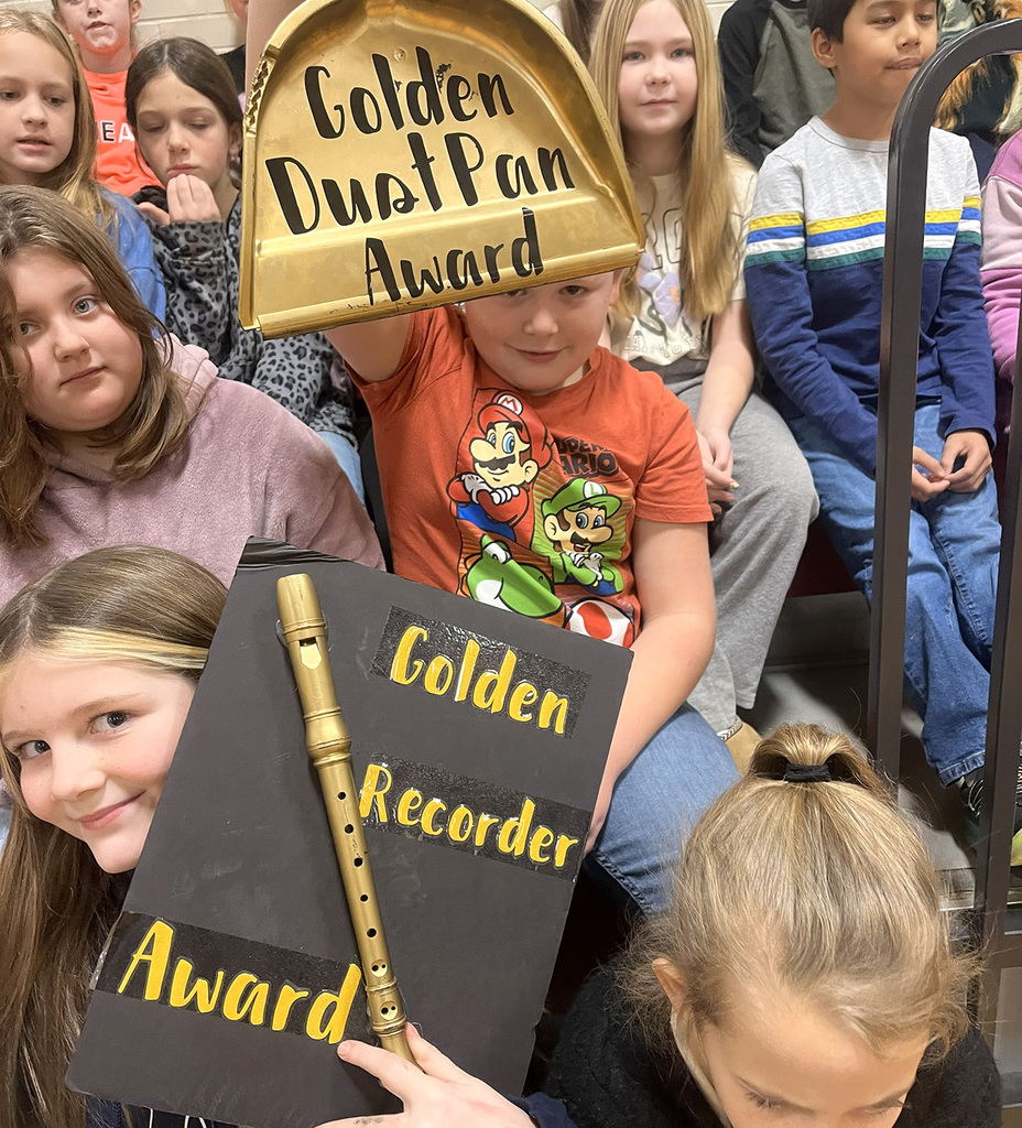 Students at Tioughnioga Riverside Academy hold two awards they received for November - Golden Dustpan Award and the Golden Recorder Award.