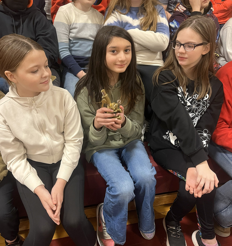 A student at Tioughnioga Riverside Academy holds her class' golden award during an assembly for fourth and fifth graders.