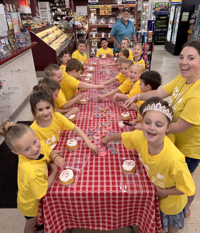 C E A  Kindergarten students decorating donuts at Gregg's Market.