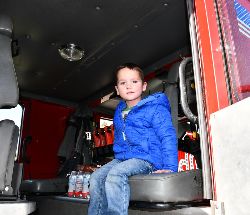 A Pre Kindergarten student sits in the seat of a fire truck that came to his school for a fire safety lesson.