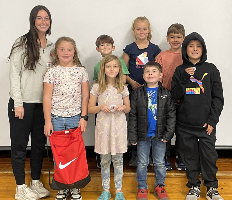 A SUNY Cortland Physical Education major with seven Caryl Adams second and third graders who participated in the after school Sports Club facilitated by the college students and their teacher.