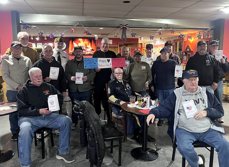 Veterans at the American Legion hold the cards that Mrs. Zabadal's fifth graders made for them in honor of Veteans Day.