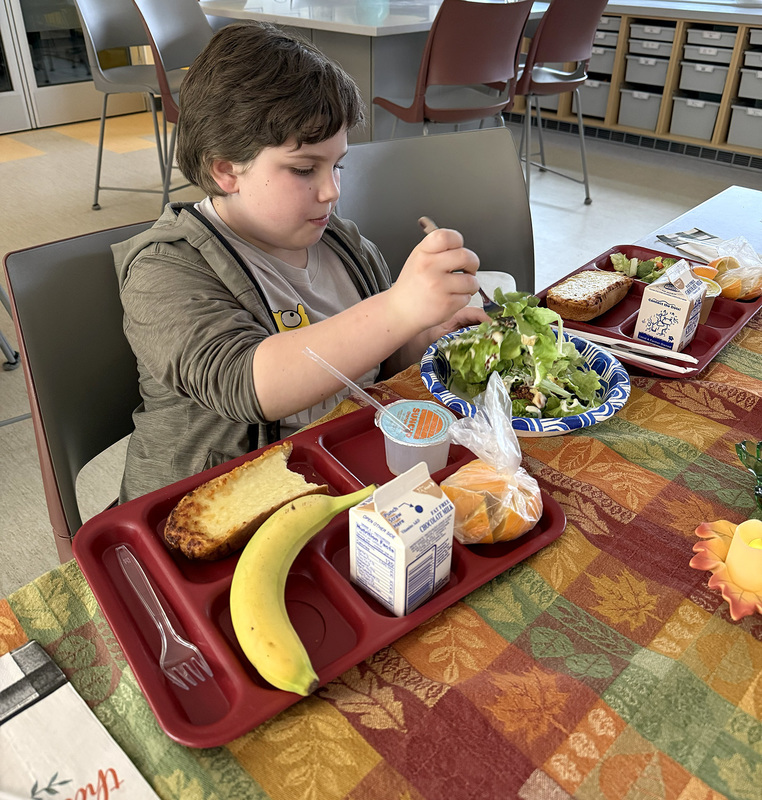 A fourth grader sticks his fork into a salad made with lettuce he helped grow with his clasmates.