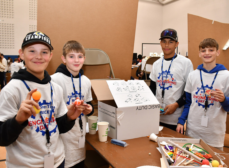 Another T R A team holds some of their materials as they build their Rube Goldberg machine during Middle School Engineering Day.