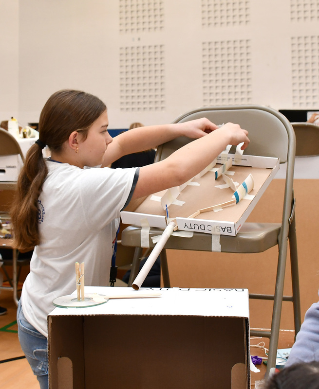 A T R A student positions a chute for her teams Rube Goldberg machine.