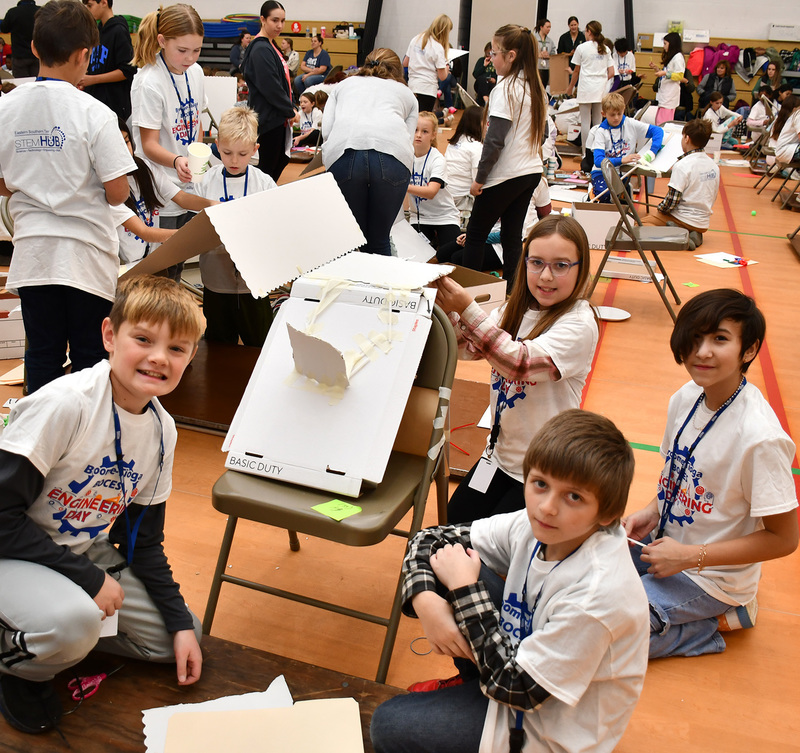 T R A teammates working on their machine.