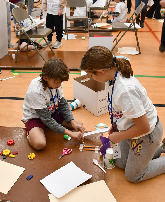 Two T R A teammates work together on constructing their Rube Goldberg machine for the Elementary Engineering Day at Broome Tioga BOCES.
