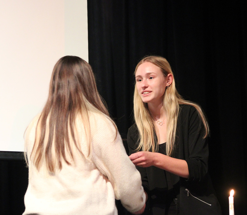 The Vice President of the Whitney Point High School National Honor Society shakes the hand of a new inductee during the induction ceremony on December 4, 2025.