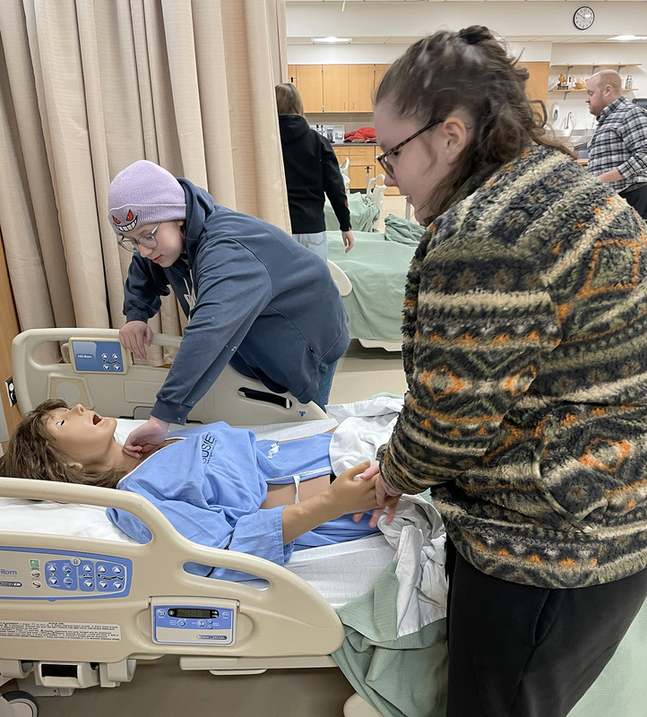 Two more students see how nursing students at SUNY Broome practice on dummies when learning skills.