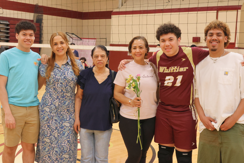 Justin Reynoso, a senior volleyball player smiling with his family.