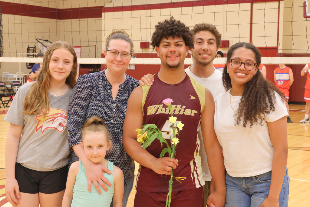 Carlos Dominguez, a senior volleyball player smiling with his family.
