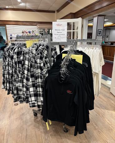 Clothing items displayed in the School Store have reduced prices for the end of the year.