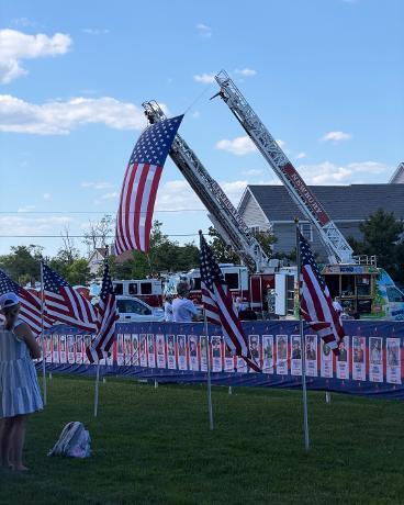 Fire Trucks from Newburyport and Newbury hold a flag