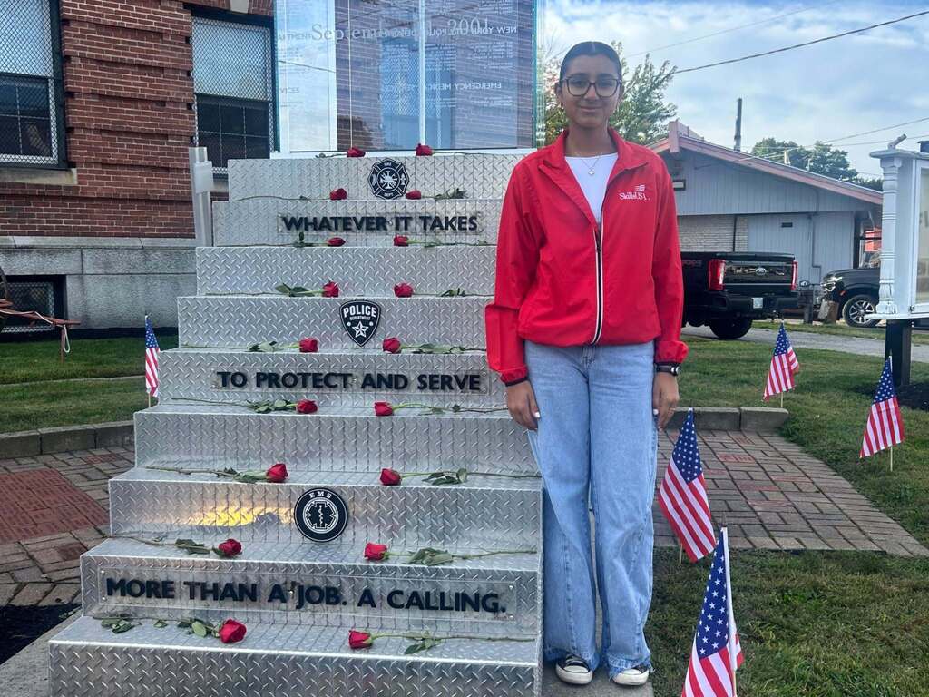 WT Student standing in front of the Haverhill Firefighting Museum's 9/11 Memorial.