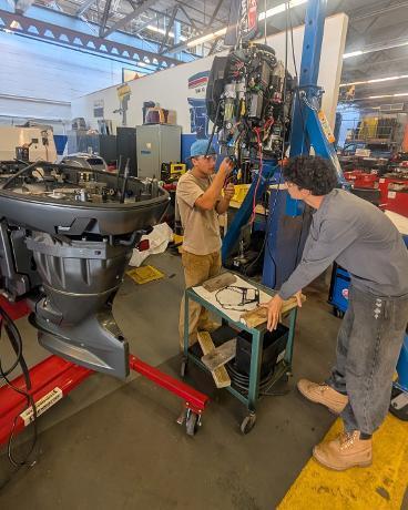 Marine Tech Students working on a boat engine.