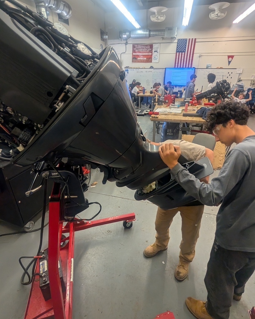 Marine Tech Students working on a boat engine.