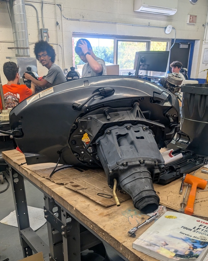 Marine Tech Students working on a boat engine.