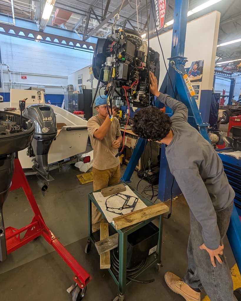 Marine Tech Students working on a boat engine.