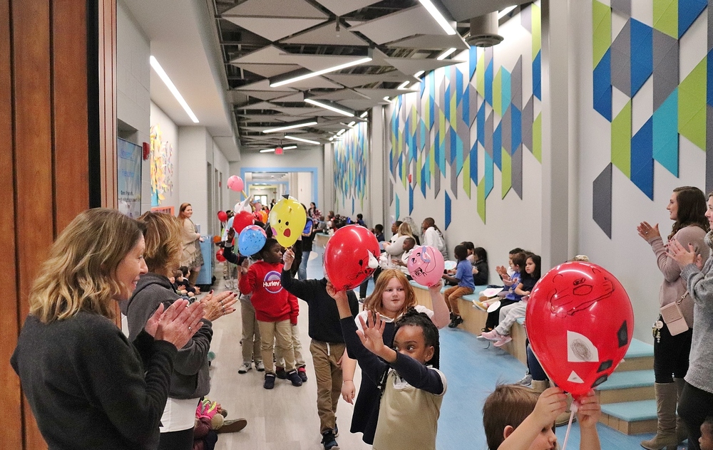 Students in a balloon parade through the hallways of a schools