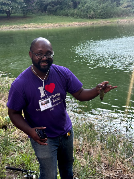 One of the Fathers holding a fish he caught.